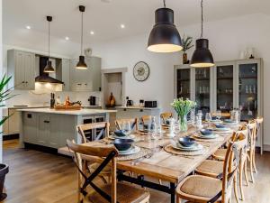 a kitchen and dining room with a long table and chairs at Walnut Tree Barn in Thetford