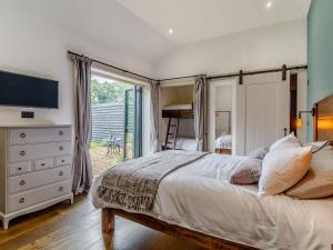 a bedroom with a bed and a dresser with a television at Walnut Tree Barn in Thetford