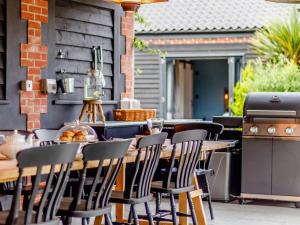 a patio with a table and chairs and a grill at Walnut Tree Barn in Thetford