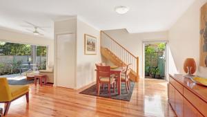 a dining room and living room with a table and chairs at Binda Beauty in Hawks Nest +2 photos