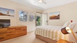 a bedroom with a bed and a flat screen tv at Binda Beauty in Hawks Nest