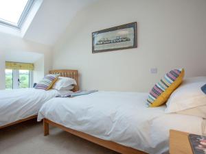 2 łóżka w pokoju z białymi ścianami w obiekcie Upper Red Down - Uk37699 w mieście Witheridge