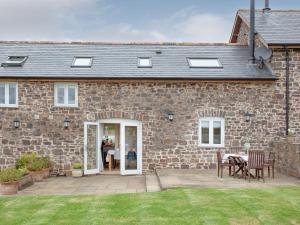 a brick house with a patio and a table at Upper Red Down - Uk37699 in Witheridge
