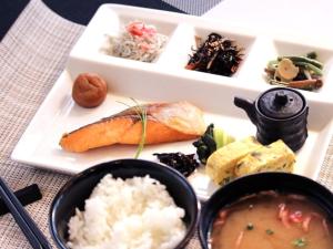 een bord eten met sushi en rijst op een tafel bij BREATH HOTEL in Kamakura