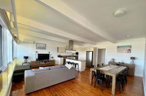 a living room with a couch and a table at Entire home on the beach in Shellharbour