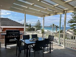 a patio with a table and chairs and a grill at Entire home on the beach in Shellharbour
