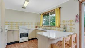 a kitchen with a white counter and a window at 4 Kururma Crescent Hawks Nest in Hawks Nest