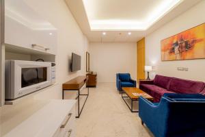 a living room with a couch and a tv at ELLAA RESIDENCES in Hyderabad
