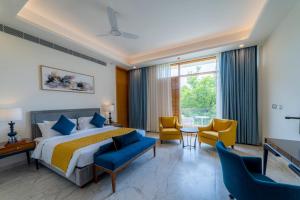 a hotel room with a bed and two chairs at ELLAA RESIDENCES in Hyderabad +32 photos