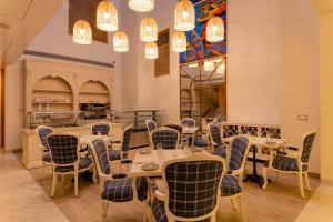 a dining room with tables and chairs and chandeliers at ELLAA RESIDENCES in Hyderabad