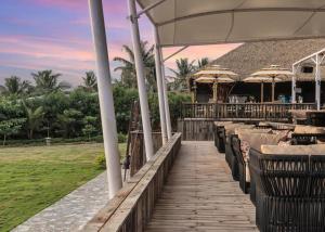 um passeio marítimo que leva a um restaurante com mesas e cadeiras em Mayfair On Sea, Morjim Beach, Goa em Morjim