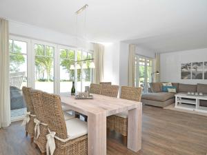 a dining room with a wooden table and chairs at Reethus am Strand - Haushälfte 2 mit Kamin, Sauna in Lobbe