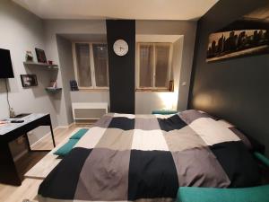 um quarto com uma cama e um relógio na parede em Studio tout confort 2 personnes au coeur de l'Alsace em Wolxheim