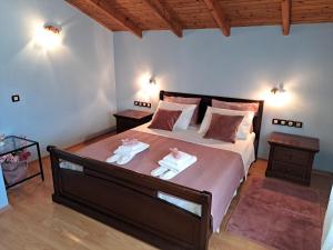 una camera da letto con un letto grande con due asciugamani sopra di Corfu Maisonette House ad Alepoú