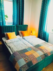 1 dormitorio con 1 cama con edredón en Apartamenty Zakładowa, en Paczków