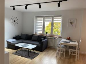 een woonkamer met een bank en een tafel bij Apartament Cynamon II in Sandomierz