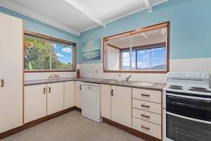 a kitchen with white cabinets and a stove top oven at Bally High, 20 Dulconghi Street in Crescent Head