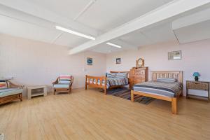 Habitación con 2 camas y una silla. en Bally High, 20 Dulconghi Street, en Crescent Head