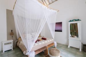 a bedroom with a bed with a mosquito net at Villa Papaya Bingin in Uluwatu +27 photos