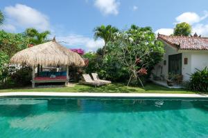 a resort with a swimming pool and a house at Villa Papaya Bingin in Uluwatu