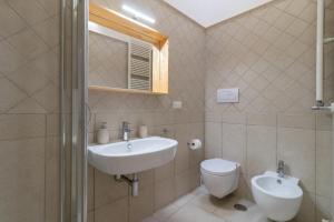 een badkamer met een wastafel en een toilet en een raam bij Casa Maestra in Ceglie Messapica +18 foto's