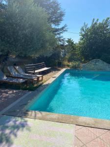 una piscina con 2 tumbonas junto a ella en GITE COCOTTE LUBERON, FORCALQUIER, en Pierrerue