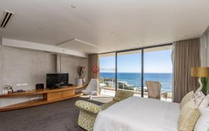 een hotelkamer met een bed en uitzicht op de oceaan bij CapeStays - Villa Infinity in Kaapstad