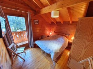 een slaapkamer met een bed in een houten huis bij Chalet individuel 8 pers à Chatel Porte du soleil avec Jacuzzi exterieur in Châtel