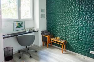 a desk and a chair in a room with a green wall at On the Castle Hill, near Chain Bridge in Budapest