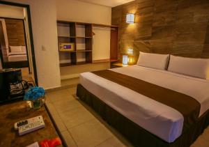 een slaapkamer met een groot bed in een hotelkamer bij Tukan Hotel Playa del Carmen in Playa del Carmen