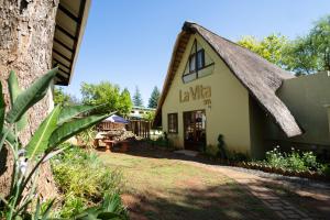 ein Gebäude mit einem Strohdach in der Unterkunft Gooderson Monks Cowl Golf Resort in Champagne Valley