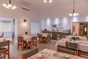 a dining room with tables and chairs and a kitchen at Maltahöhe Hotel in Maltahöhe