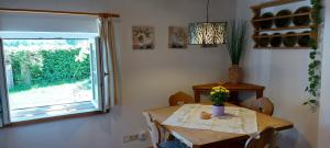 a dining room with a table and a window at Ruhig gelegene Ferienwohnung mit gemütlichem Kamin in Rotthalmünster