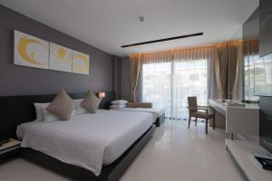 sypialnia z 2 łóżkami, biurkiem i telewizorem w obiekcie Patong Beachfront Studio 2 Mins Walk 2 Patong Beach w Patong Beach