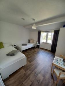 a bedroom with two beds and a wooden floor at Lütje Huus in Upgant-Schott