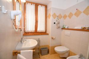 a bathroom with a sink and a toilet at Room & Breakfast Cà mea Dina in Ledro