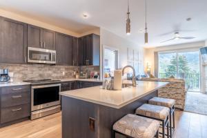 a kitchen with wooden cabinets and a large kitchen island at Sail Lofts by Summit County Mountain Retreats in Dillon
