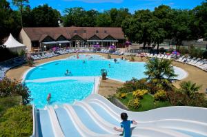 a pool at a resort with people in the water at Agréable Mobilhome 6 - 8 places in Saint-Brevin-les-Pins