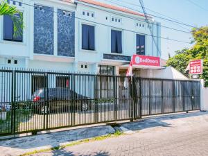 een zwart hek voor een gebouw bij RedDoorz Syariah at Jemursari Surabaya in Surabaya