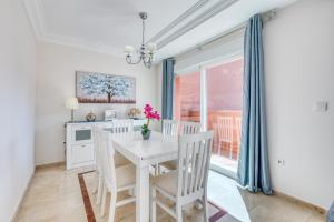 een witte eetkamer met een witte tafel en stoelen bij La Fragata Penthouse LF1 in Estepona