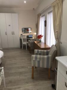 a kitchen and living room with a desk and a table at Summer Place, Southern Cross Drive, Constantia, Cape Town in Cape Town