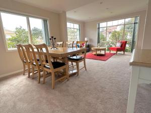 jadalnia z drewnianym stołem i krzesłami w obiekcie Cheerful 4 bedrooms home with stunning sunshine w Auckland
