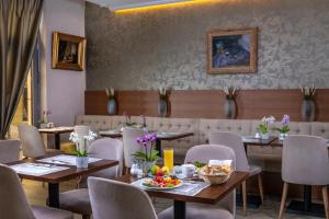 ein Restaurant mit Tischen und Stühlen mit Essen darauf in der Unterkunft Boutique Hotel Budapest in Budapest