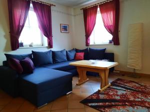 ein Wohnzimmer mit einem blauen Sofa und einem Tisch in der Unterkunft Ferienhaus Bad Waltersdorf in Bad Waltersdorf