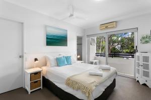 a white bedroom with a bed and a window at Riviera Noosa Resort in Noosaville +20 photos
