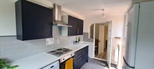 a kitchen with black cabinets and a white counter top at Sipson House West Drayton 3 bedroom 2 bathroom Plush parking close to LHR By MDPS in West Drayton