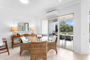 a living room with a glass table and chairs at Riviera Noosa Resort in Noosaville