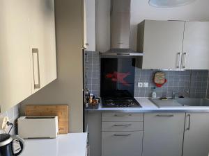 a kitchen with white cabinets and a stove top oven at Le Sainte Marie in Compiègne