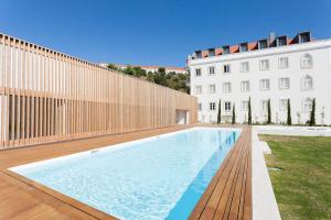 einem Pool vor einem weißen Gebäude in der Unterkunft FLH Mouraria Art Apartment with Pool in Lissabon