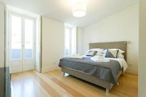 a bedroom with a bed with blue and white pillows at FLH Mouraria Art Apartment with Pool in Lisbon